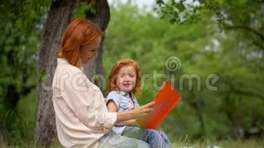 母亲和女孩<strong>坐在树下</strong>看书