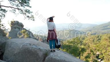 一位女士举着<strong>双</strong>臂站在山顶看着风景远足的女孩举起手臂<strong>庆</strong>祝风景