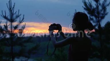 在海滩上拍照的女孩。 日落女孩与照片相机在复古时髦的设计制作照片