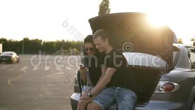 一对年轻的白种人夫妇坐在<strong>敞篷</strong>车里的慢镜头。 男孩拥抱和抚摸她的女孩