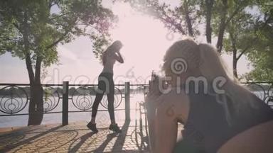 金发女人为她的朋友<strong>拍照</strong>，其他女人摆姿势<strong>拍照</strong>，美丽的风景，公园附近的河流背景