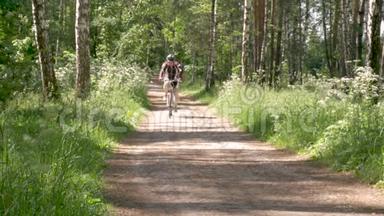一个人正在森林小径上骑自行车。 他过着健康的生活方式