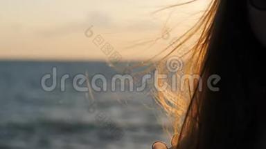 飘扬的头发。 日落时海上的女孩