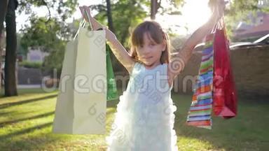 儿童购物，小女孩买家喜欢新购买的包装，并举手公园
