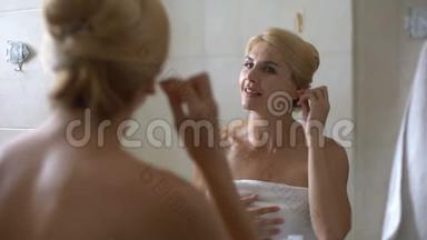 年轻女子在浴室用<strong>棉签</strong>清洁耳朵，早晨程序健康