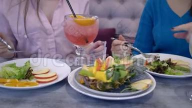 <strong>女人节</strong>食，女朋友午餐时与水果和蔬菜交流，喝新鲜果汁坐在餐桌旁