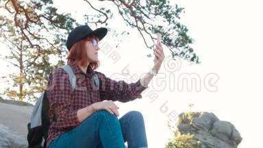 山顶上的女孩，女游客在手机上用日出拍照