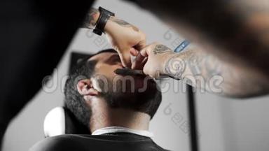 理发师用直剃须<strong>刀刮</strong>顾客，在理发店`理发和<strong>刮胡子</strong>