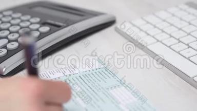 电脑键盘旁桌子上妇女填税表1040及计算退税的及计算退税