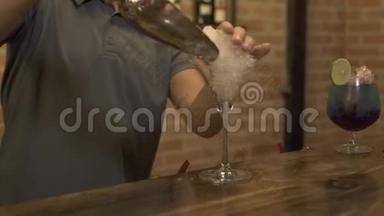 酒保把<strong>碎冰</strong>放在玻璃杯里，在餐厅的吧台上做鸡尾酒。酒保准备酒