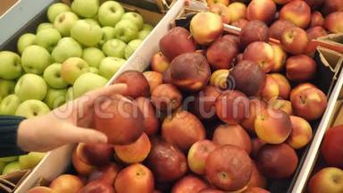 挑选新鲜红苹果的女人在杂货店生产超市销售