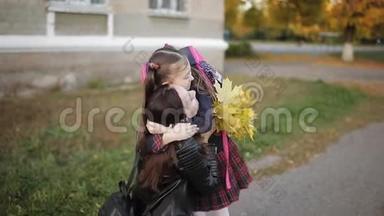 放学后，母女俩拥抱在学校附近。 妈妈从学校接女儿。