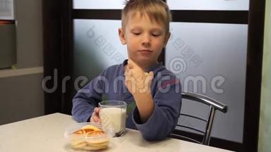 小男孩从杯子里喝牛奶。