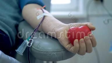 一个人在输血中心献血时挤压一个球。