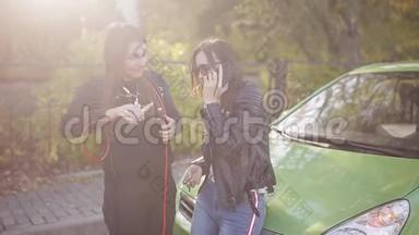 两个女人在路上的破车附近打手机。 路上的问题.. 汽车的故障。