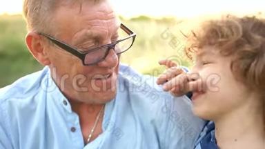 祖父和孙子的特写肖像。 两代人在大自然中玩得很开心-笑和<strong>愚</strong>弄。 快<strong>乐</strong>