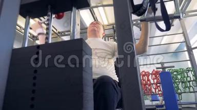 一个残疾人正在健身房练习举重机