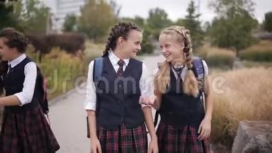 穿着同样校服的女学生背着背包在公园里嬉笑打闹