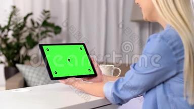 女子有视频通话平板电脑与绿色屏幕