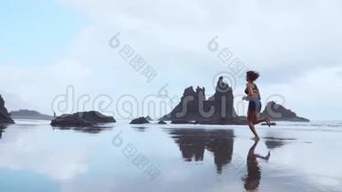 女人在冰冻<strong>岩浆</strong>背景下的加那利群岛黑色火山沙上奔跑。 健康的概念