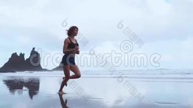女人在冰冻<strong>岩浆</strong>背景下的加那利群岛黑色火山沙上奔跑。 健康的概念