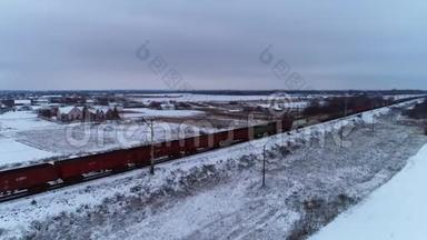 一列很长的火车经过一个覆盖着雪的小村庄，空中射击