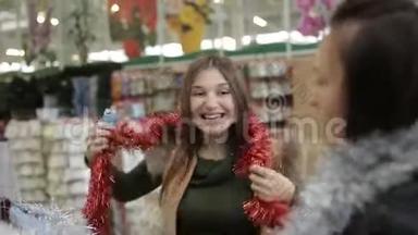 圣诞义卖的超市里的朋友们选择五颜六色的铁皮装饰圣诞树。