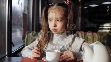 可爱的小<strong>女孩</strong>用糖果<strong>喝茶</strong>，坐在窗边，做着梦