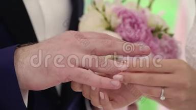 结婚纪念日。 新郎把戒指放在新娘`手上。