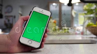 女人拿着绿色屏幕iphone和模糊的餐厅