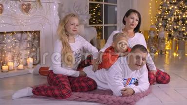 家庭<strong>爸爸妈妈</strong>，女儿和儿子在圣诞树和壁炉的背景
