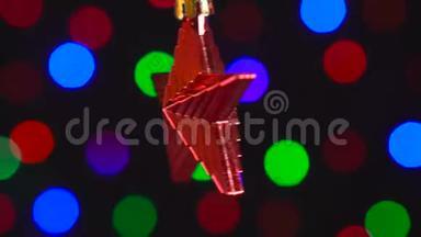 圣诞红星玩具正在旋转特写。 装饰与新年树<strong>灯闪烁</strong>的背景