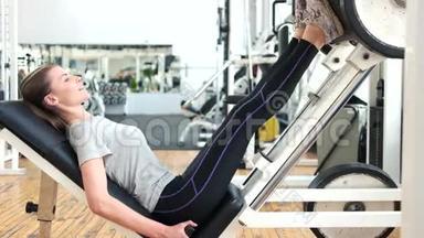 女人在<strong>健身</strong>房用<strong>减肥</strong>机做腿。