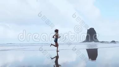 赤足运动的女孩，苗条的身体沿着海水在游泳池冲浪，以保持健康和健康。 海滩背景