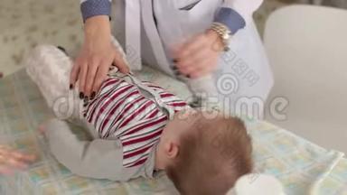 一位女医生在<strong>医院的</strong>一张换洗<strong>的</strong>桌子上检查一个新生儿。