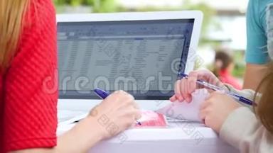 一位女士为一台白色笔记本电脑工作，填写<strong>问卷</strong>
