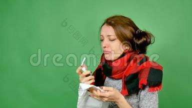 一个有吸引力的黑发流感的肖像。 女孩感冒了，发烧了，脖子上裹着围巾。 她喷了喉咙