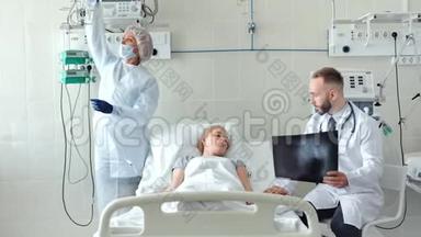 男医生在病床上和女<strong>病人</strong>交谈。<strong>护士</strong>在医院病房为生病的年轻妇女准备滴管