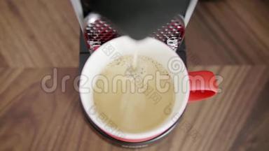卡布奇诺被倒入红色杯子中，放在自动咖啡机的托盘上。