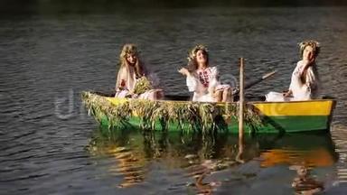 <strong>三个女孩</strong>穿着斯拉夫民族服装坐着一艘船漂浮在河上。 穿着花圈的<strong>女孩</strong>们，欢快地摆着姿势和欢笑