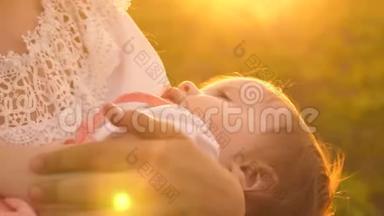一个小婴儿睡在母亲的怀里，日落时分，慢镜头拍摄，特写镜头