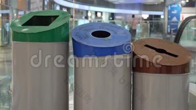 女人用纸、塑料和玻璃标志把纸回收到垃圾桶里。 废物分类和回收