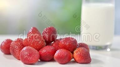 在夏季<strong>背景</strong>特写镜头中，几乎没有一个<strong>环保</strong>的真正的红色草莓靠近大杯牛奶