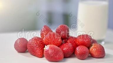 牛奶背景玻璃中白色桌面上鲜有有机草莓的特写