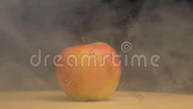旋转苹果，在黑色背景下，在烟雾中吹出凉爽和新鲜的味道，特写，缓慢的mo