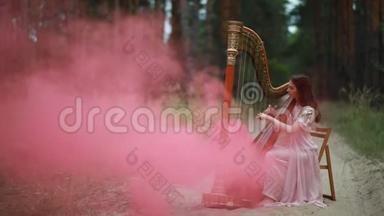 女竖琴手坐在森林里，在烟雾的背景下竖琴。