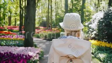 一个手里拿着智能手机的女人<strong>漫步</strong>在荷兰的基肯霍夫<strong>公园</strong>