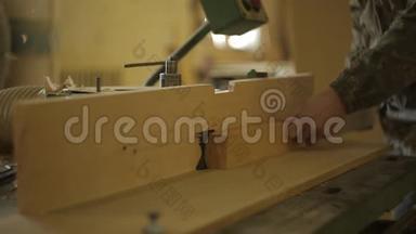 锯木厂的一名工人在一台特殊的机器上加工板材，用于切割和加工木材、特写、电锯