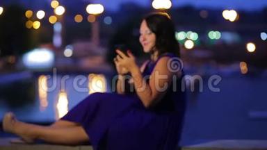 傍晚时分，一个穿着<strong>蓝色</strong>连衣裙的年轻女子坐在街上的一艘<strong>轮船</strong>上，在智能手机上微笑着读着一条信息