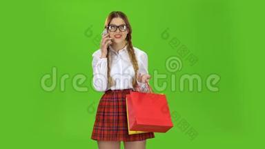 戴眼镜的青少年正在打电话，拿着一包纸。 绿色屏幕